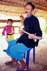 Lisu-Mann mit Kindern beim Musizieren, Lisu-Dorf in der Provinz Chiang Mai, Nord-Thailand